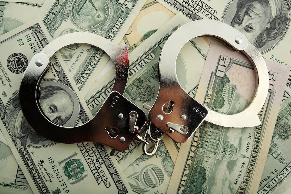 handcuff and dollar bank notes | Average Bail Amount for Felony Charge - Air Capital Bail Bonds
