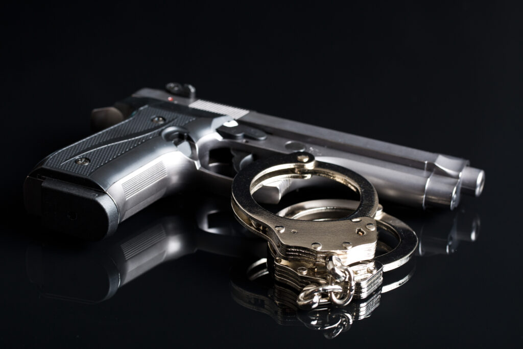 Handcuffs and Hand gun - What Is An Illegal Weapon - Air Capital Bail Bonds
